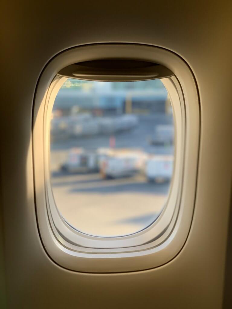 view of runway through airplane window • Kevin Harrington view of runway through airplane window