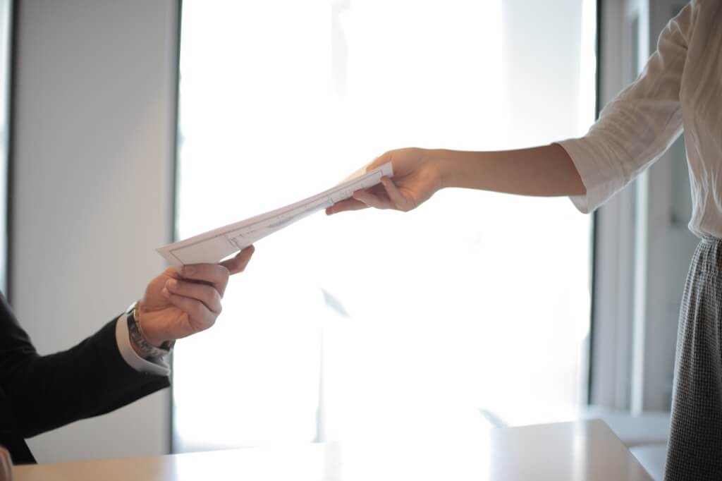 job applicant handing over her CV